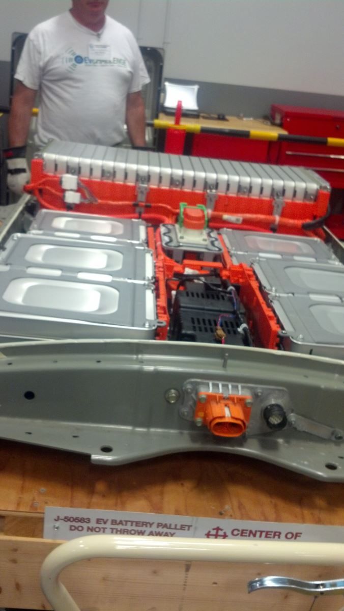 A man is standing next to a battery that is sitting on a table | Autotrends