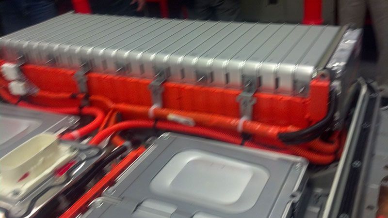 A close up of a battery with red wires coming out of it | Autotrends