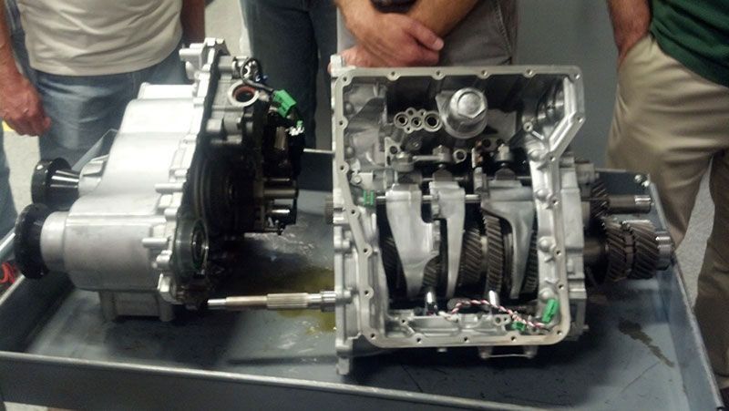 A group of men are standing around a very large engine | Autotrends