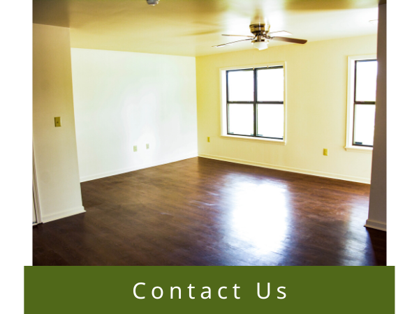 Empty living room with dark wood floors, white walls, and a green 