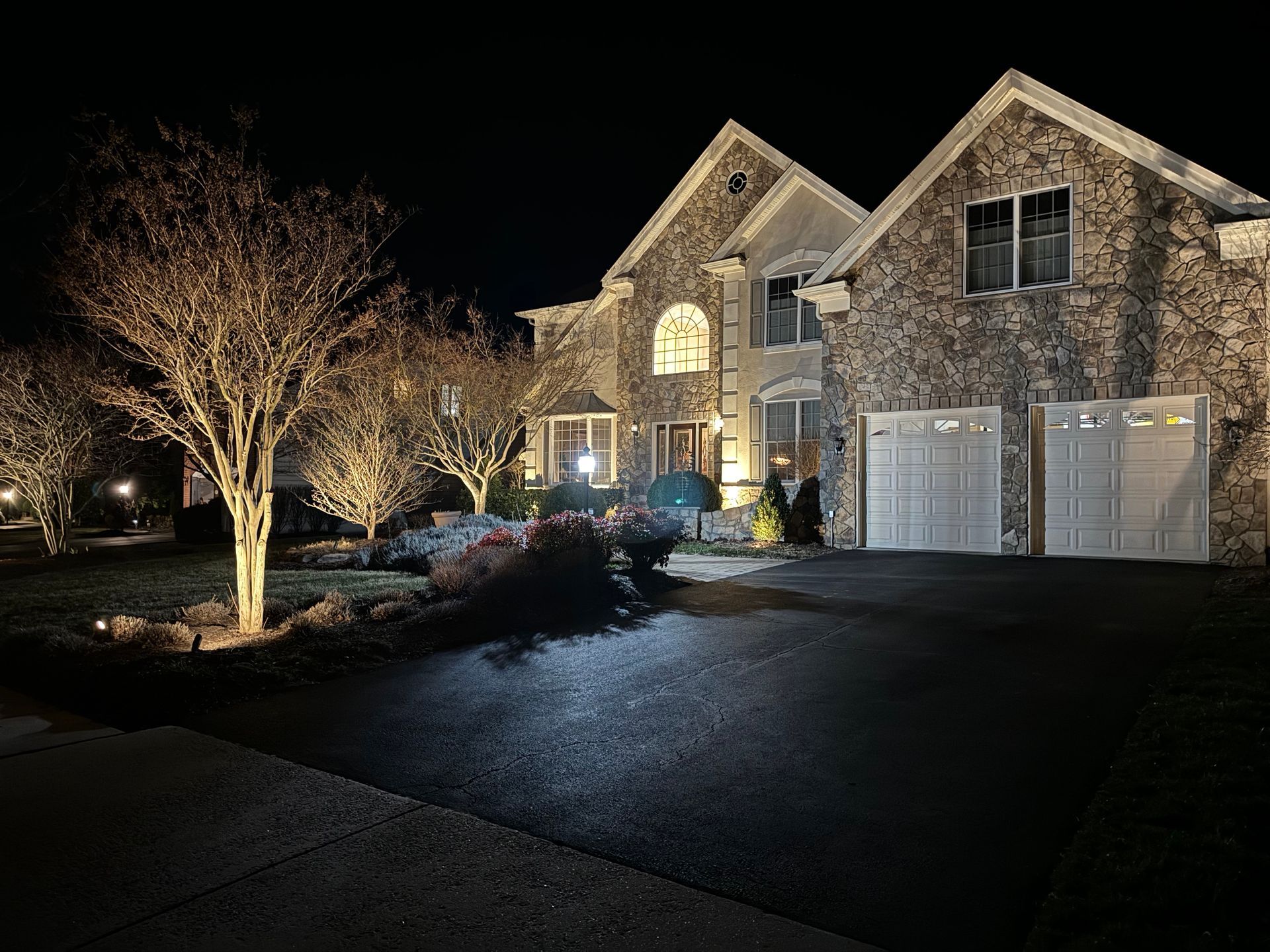 A large stone house is lit up at night.