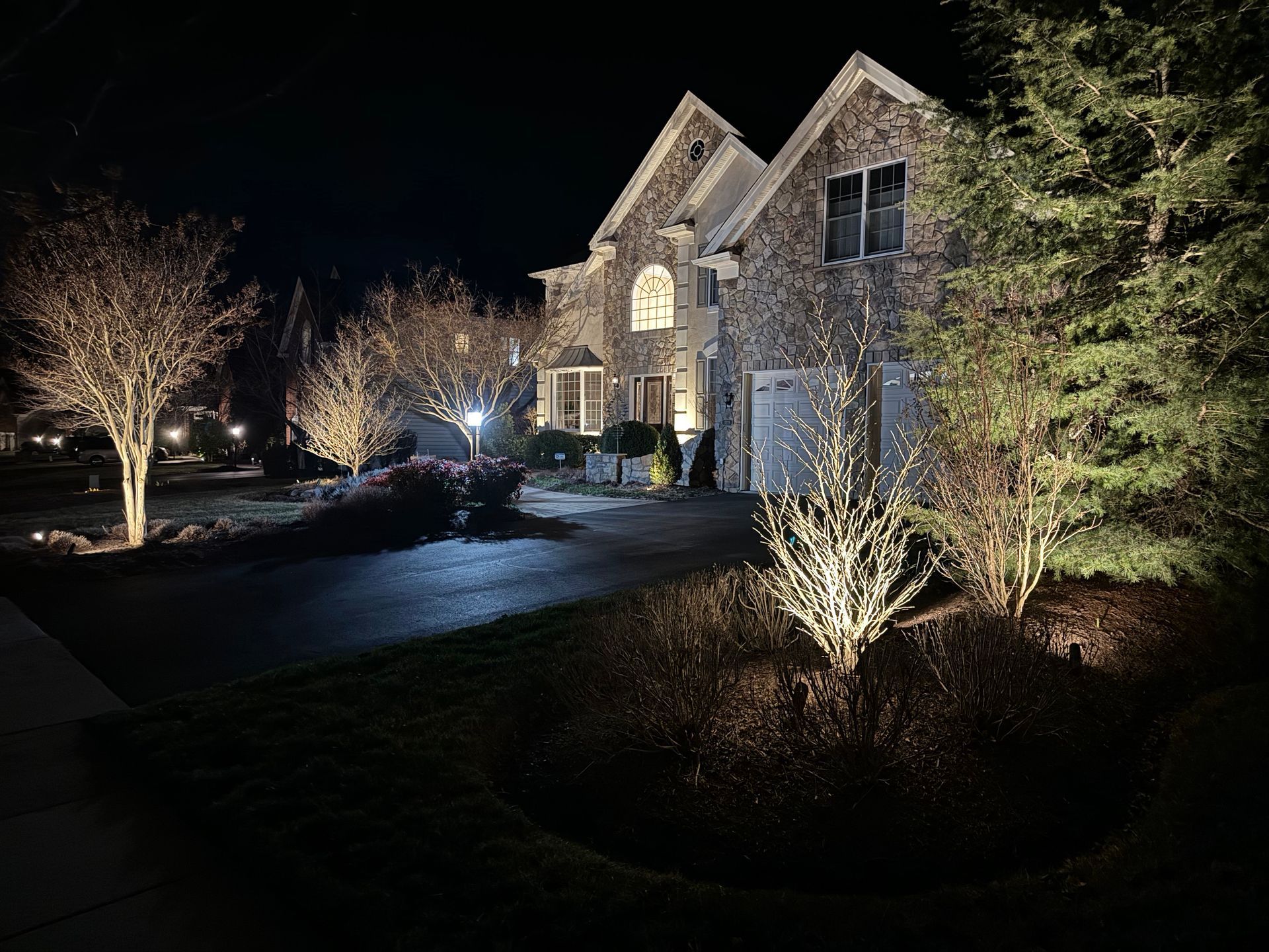 A large brick house is lit up at night.