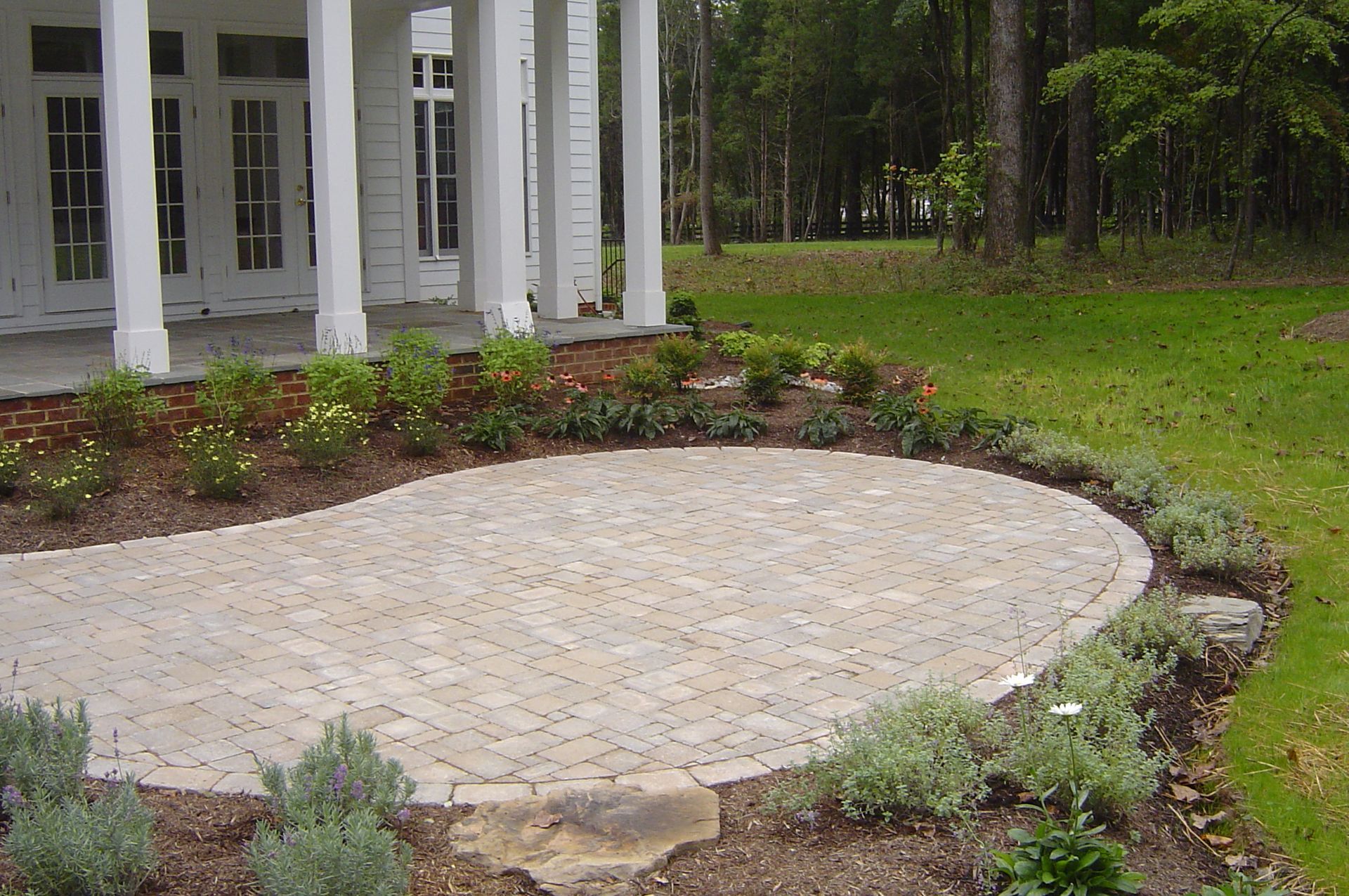A large white house with a circular patio in front of it