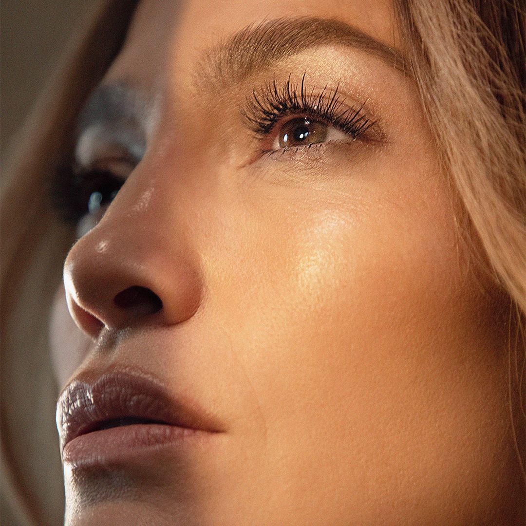 Close-up of a woman’s glowing, smooth skin and bright eyes, showcasing radiant complexion after skin