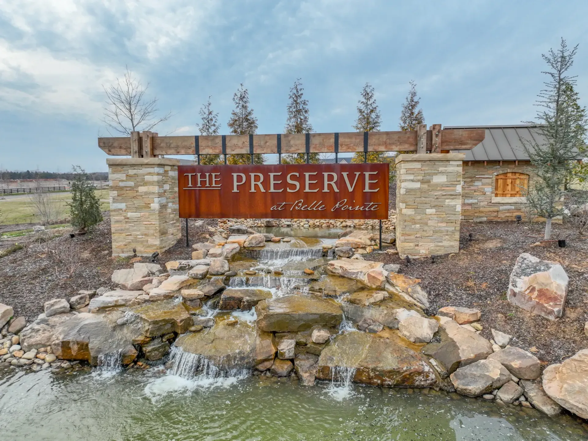 A river runs through a park surrounded by trees on a sunny day.