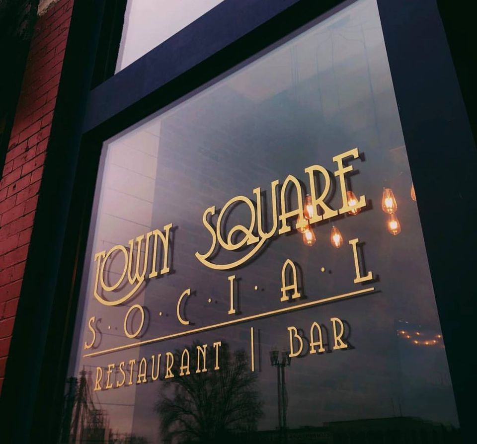 A river runs through a park surrounded by trees on a sunny day.