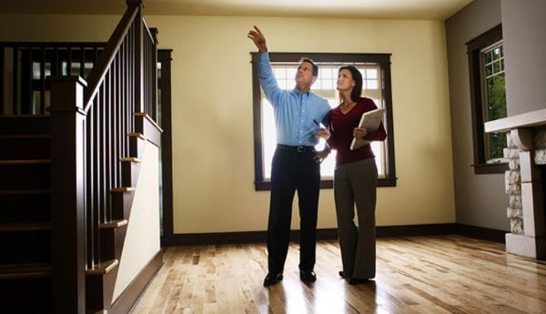 A man and a woman are looking at a house.