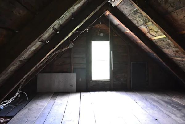 An attic with a window and a wooden floor