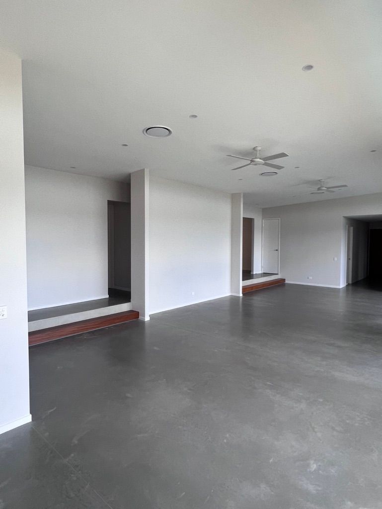 A Large Empty Room With White Walls — Dezigner Finishes Professional Painting & Decorating in Noosa Heads, QLD