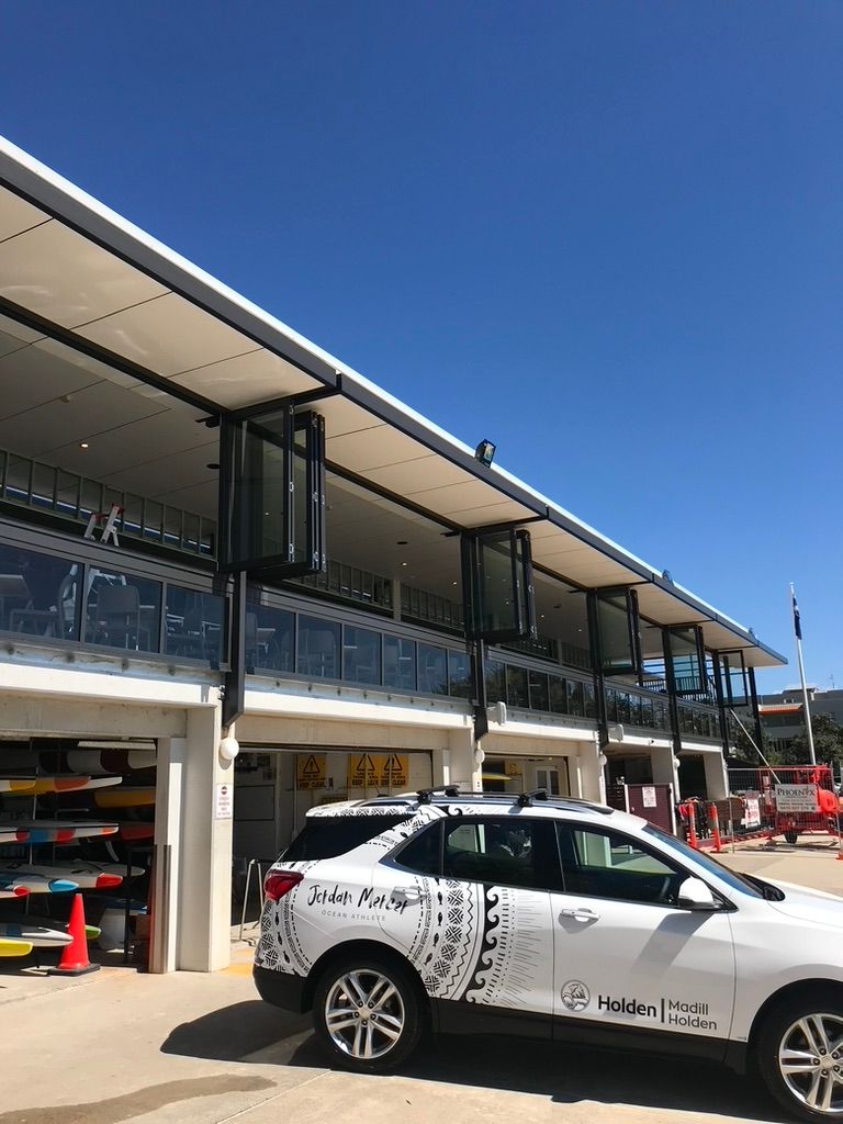 A White Car is Parked in Front of a Building — Dezigner Finishes Professional Painting & Decorating in Maroochydore, QLD