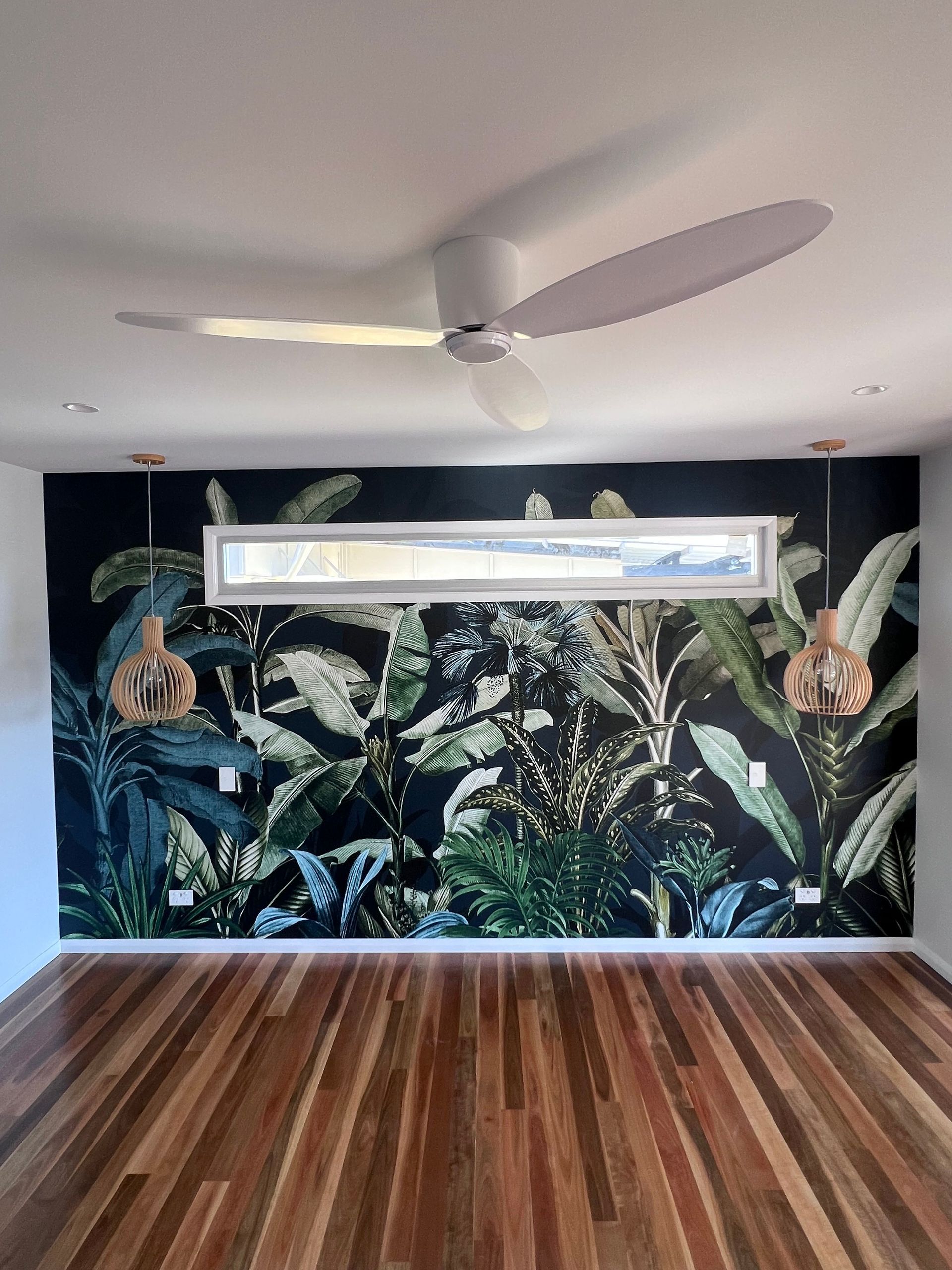 A Person is Painting a Wall With a Paint Roller — Dezigner Finishes Professional Painting & Decorating in Buderim, QLD
