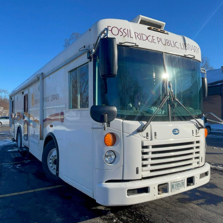 A white bus from the fossil ridge public library