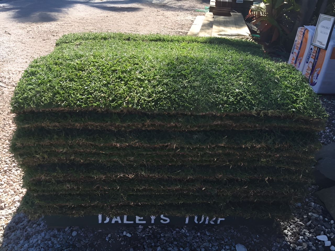 A Stack Of Bales Of Turf Is Sitting On The Ground — T&G Sand and Gravel In Sippy Downs, QLD