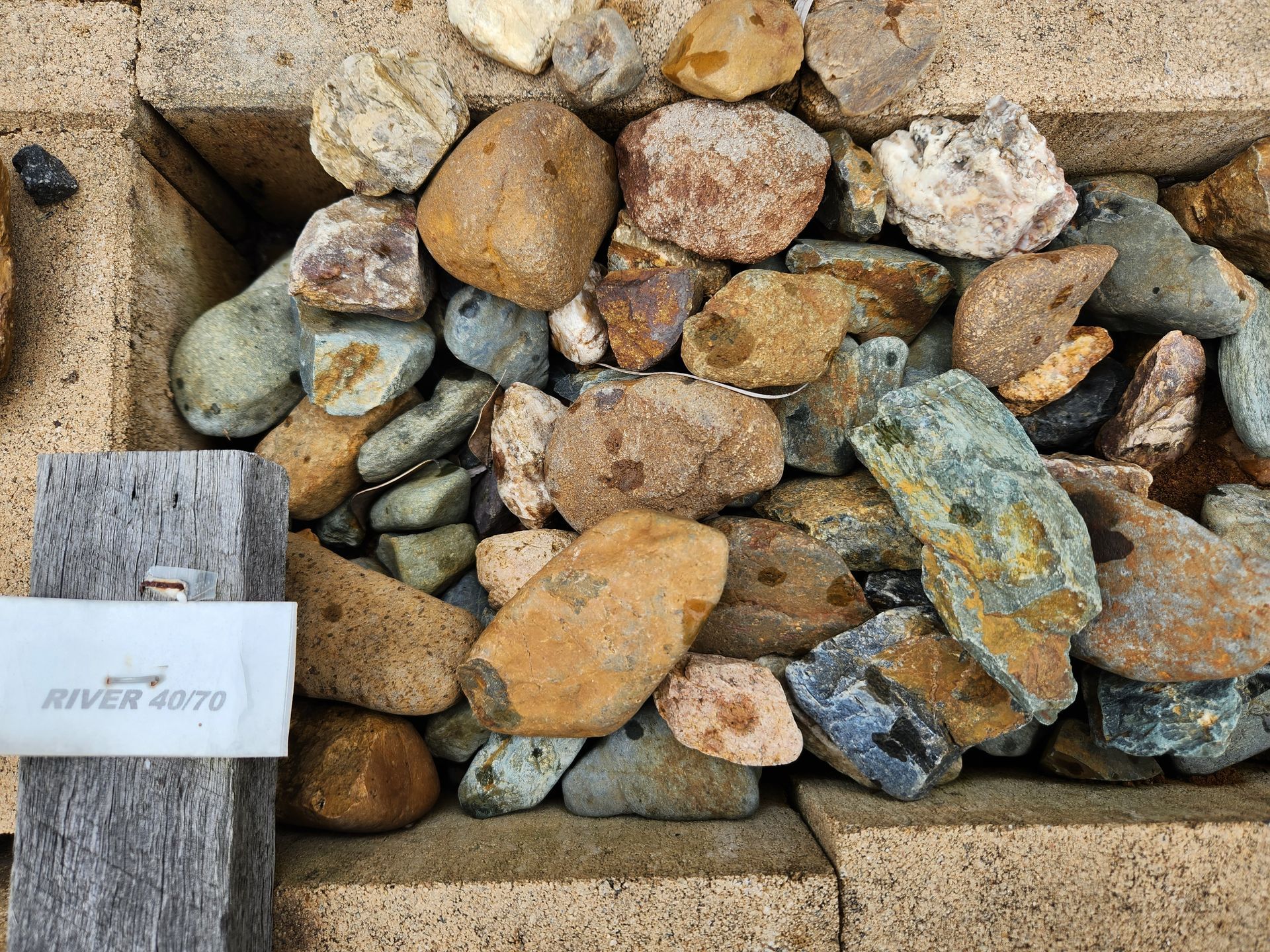 Pile of River Rocks in a Concrete Container — T&G Sand and Gravel In Sippy Downs, QLD