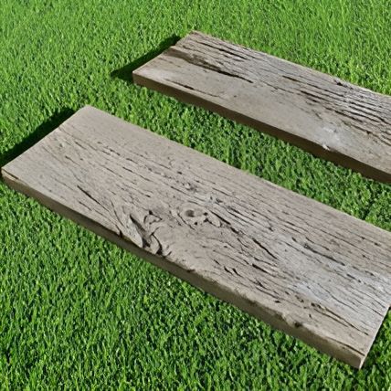 Two Wooden Boards Are Sitting On Top Of A Lush Green Field — T&G Sand and Gravel In Sippy Downs, QLD