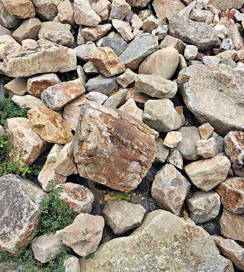 A Pile Of Rocks With Grass Growing Out Of Them — T&G Sand and Gravel In Sippy Downs, QLD