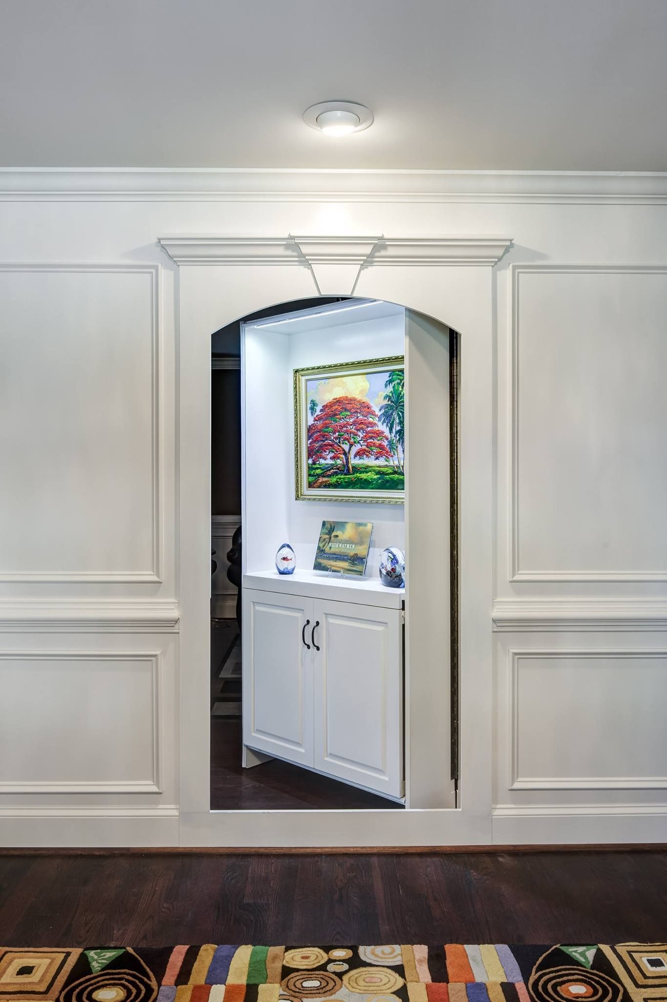 White secret door with inset cabinets and artwork.