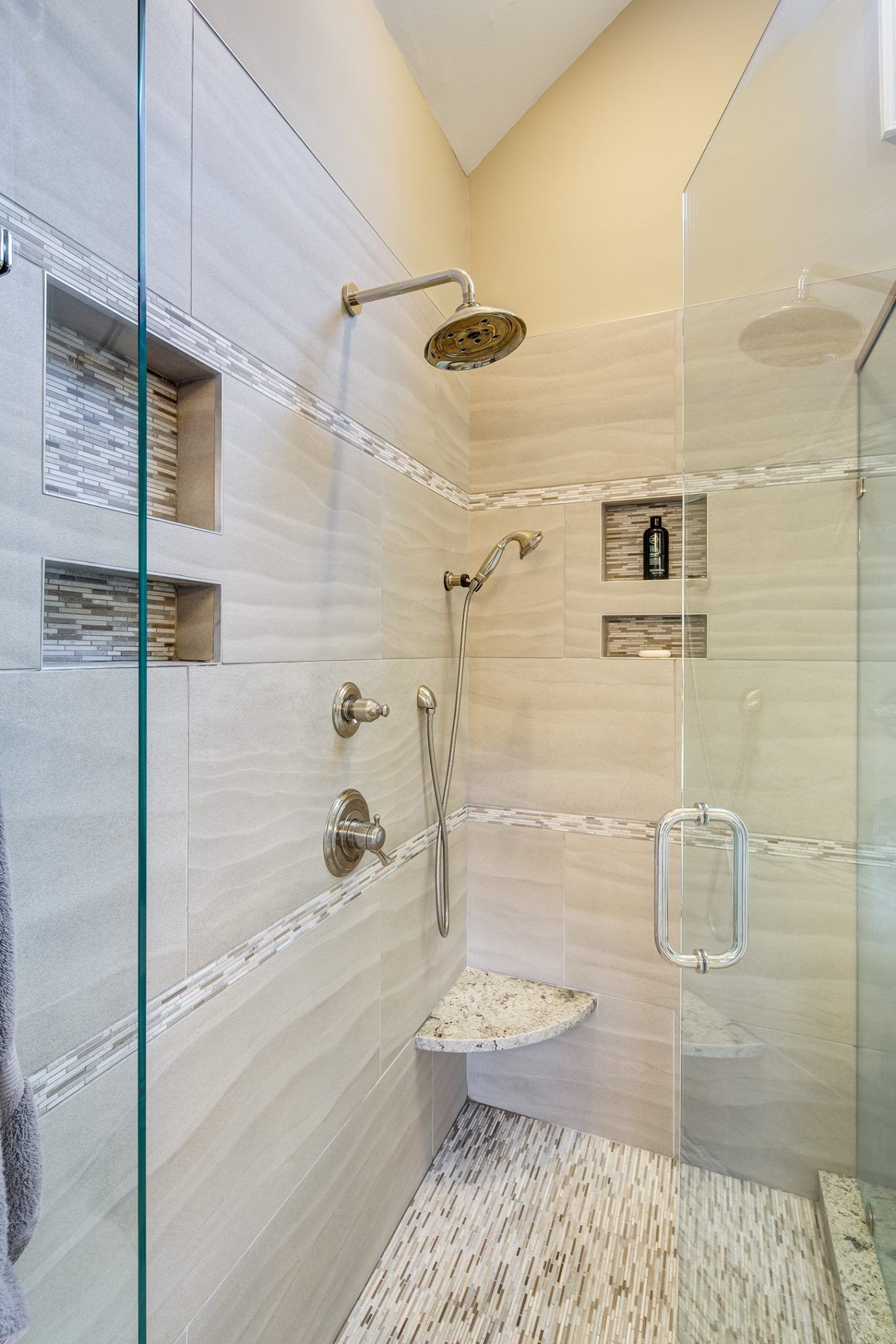Modern bathroom with beige tile and glass shower door.