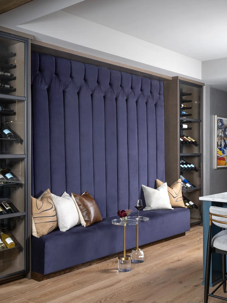 Blue velvet banquette with tall tufted back and wine storage.