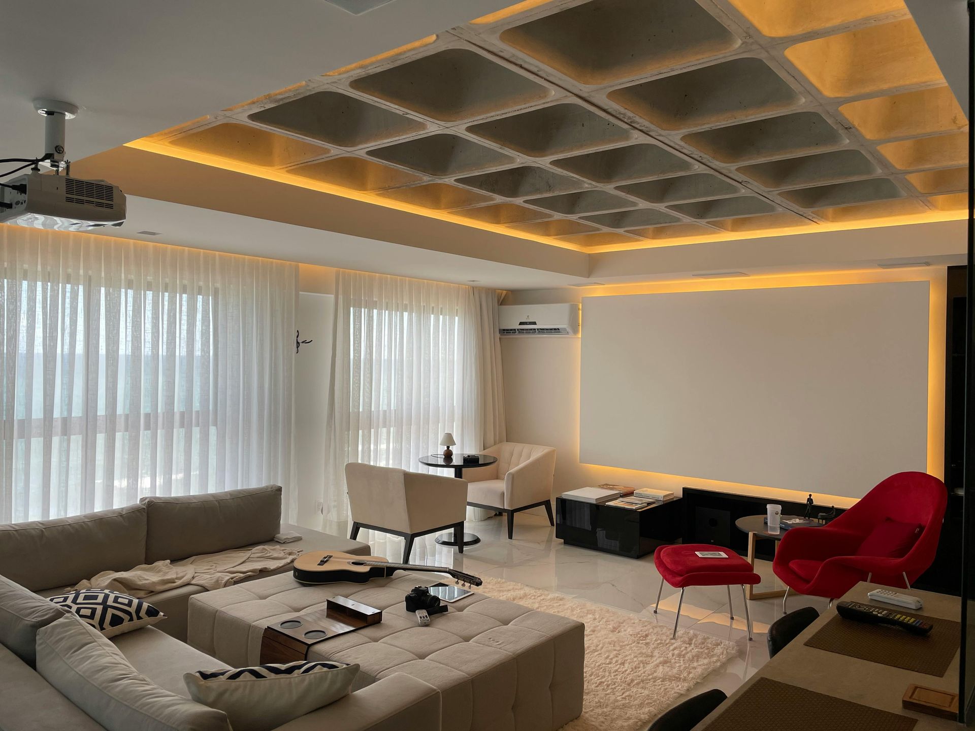 Living room with a projector screen, sofa, and decorative ceiling.