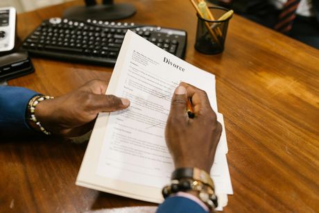 A man is sitting at a desk writing on a piece of paper.