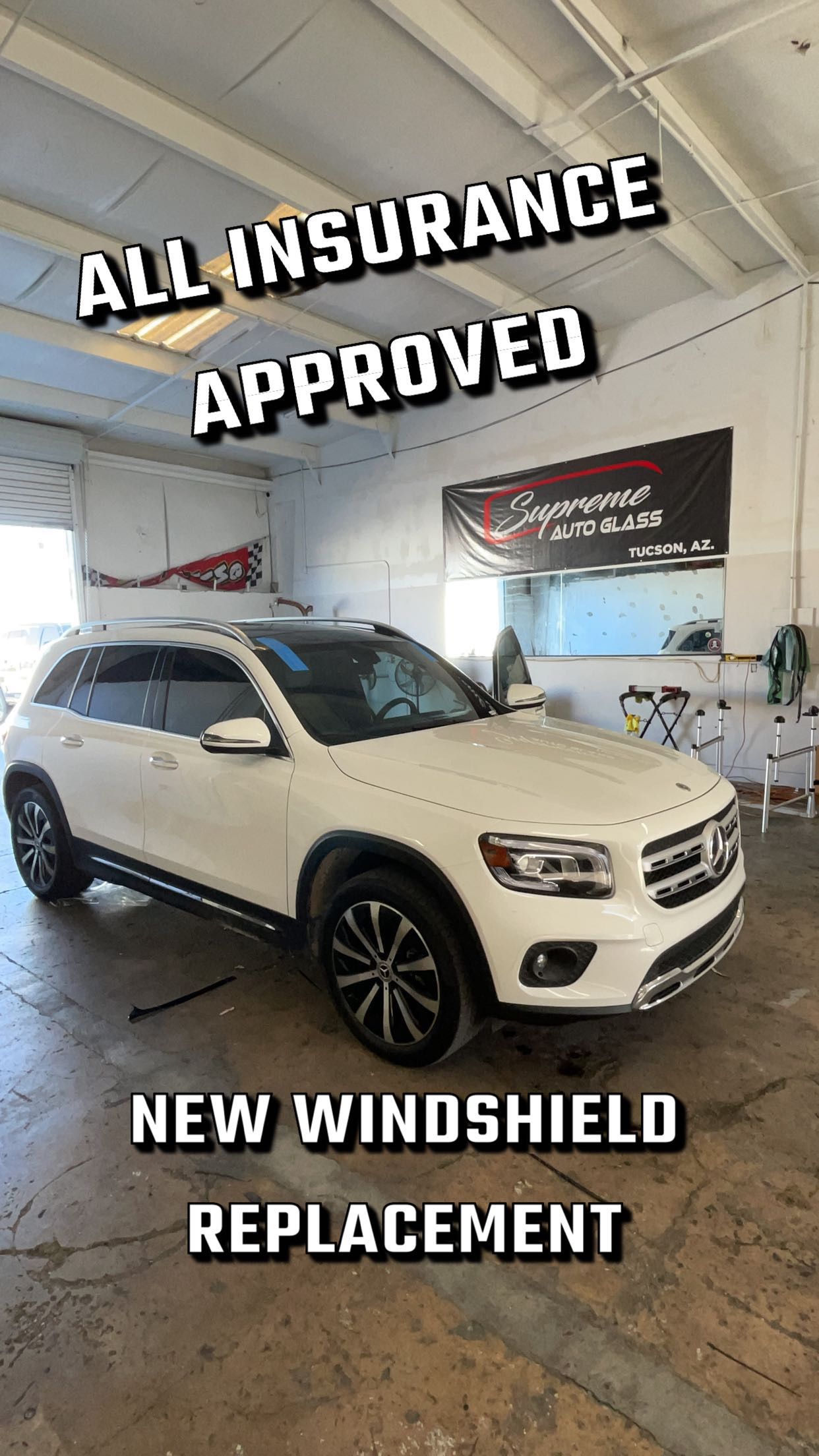 A white suv is parked in a garage with a new windshield replacement.