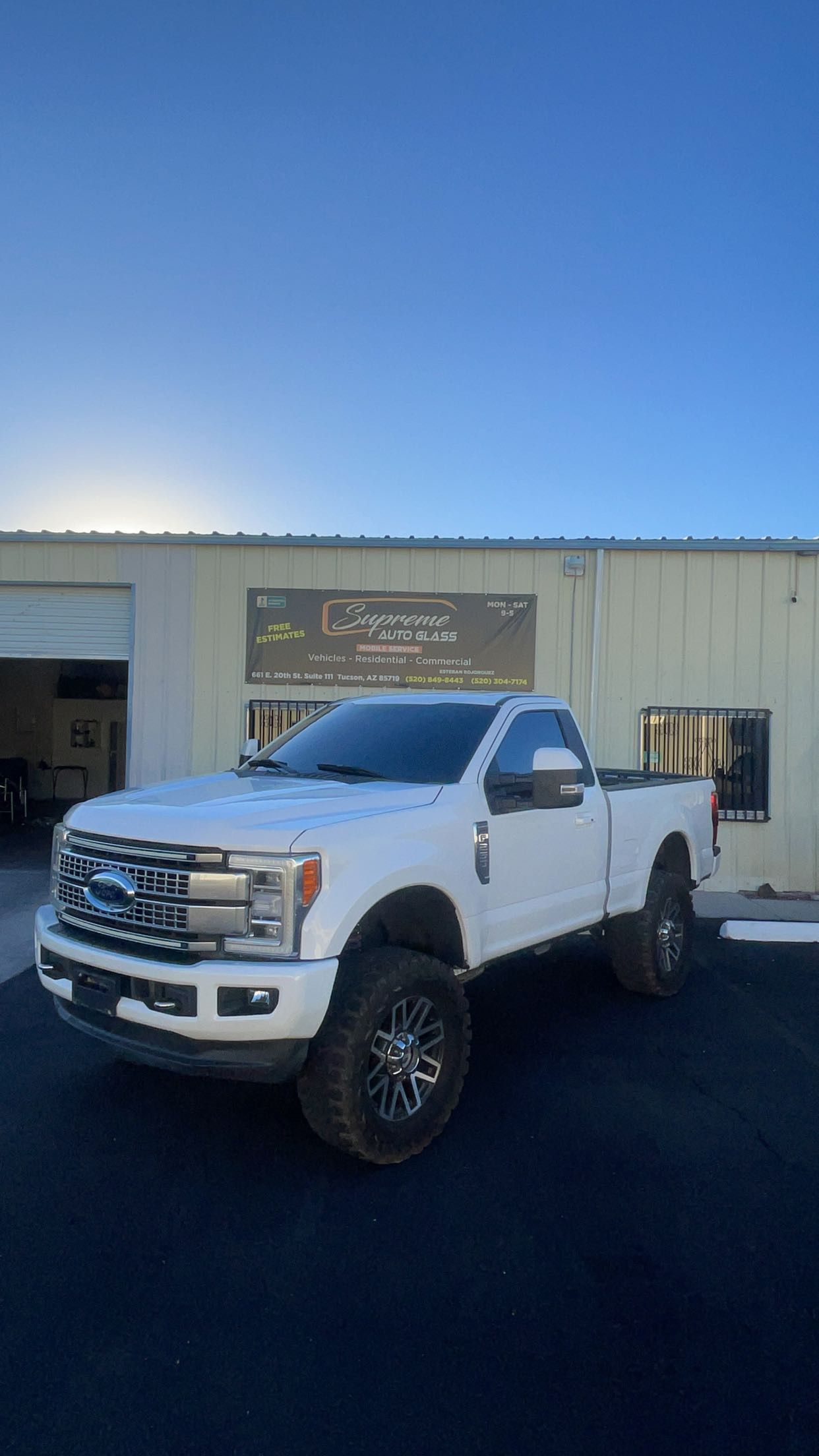 A white truck is parked in front of a building.