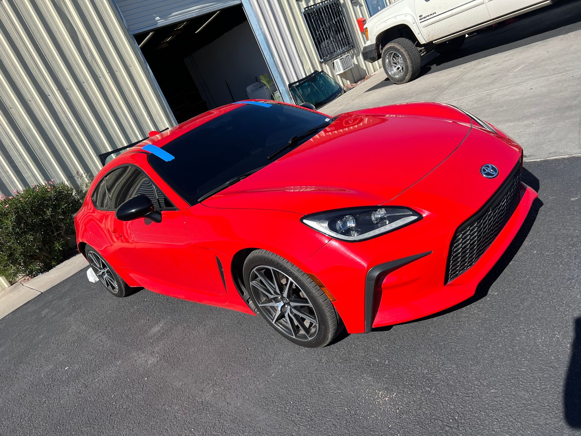 A red sports car is parked in front of a building.