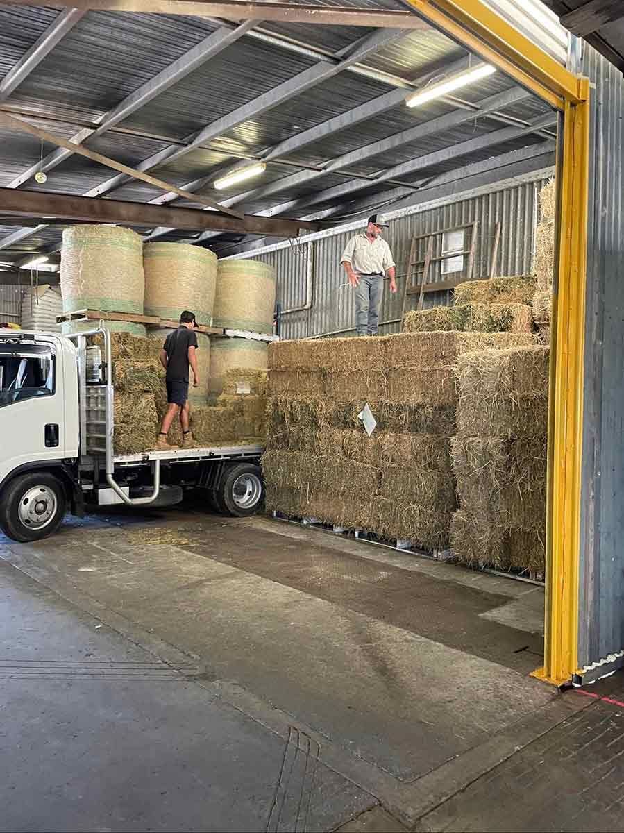 A Truck Is Loading Hay Bales Into A Warehouse — Dillon Rural In Cundletown, NSW