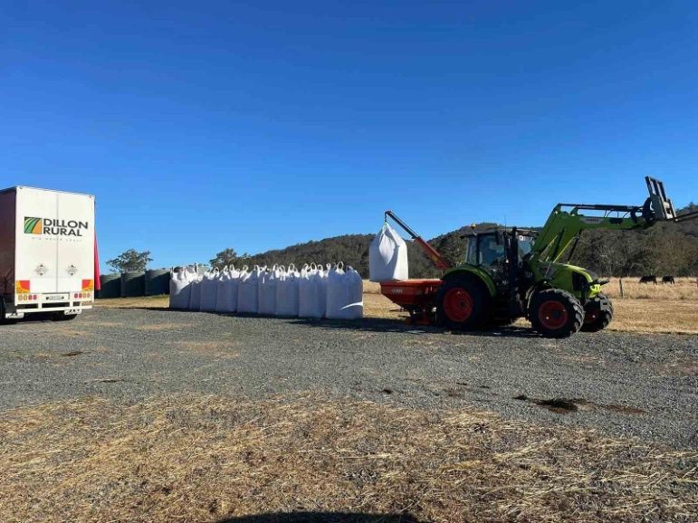 A Tractor Is Loading Bags Of Hay Into A Trailer — Dillon Rural In Cundletown, NSW