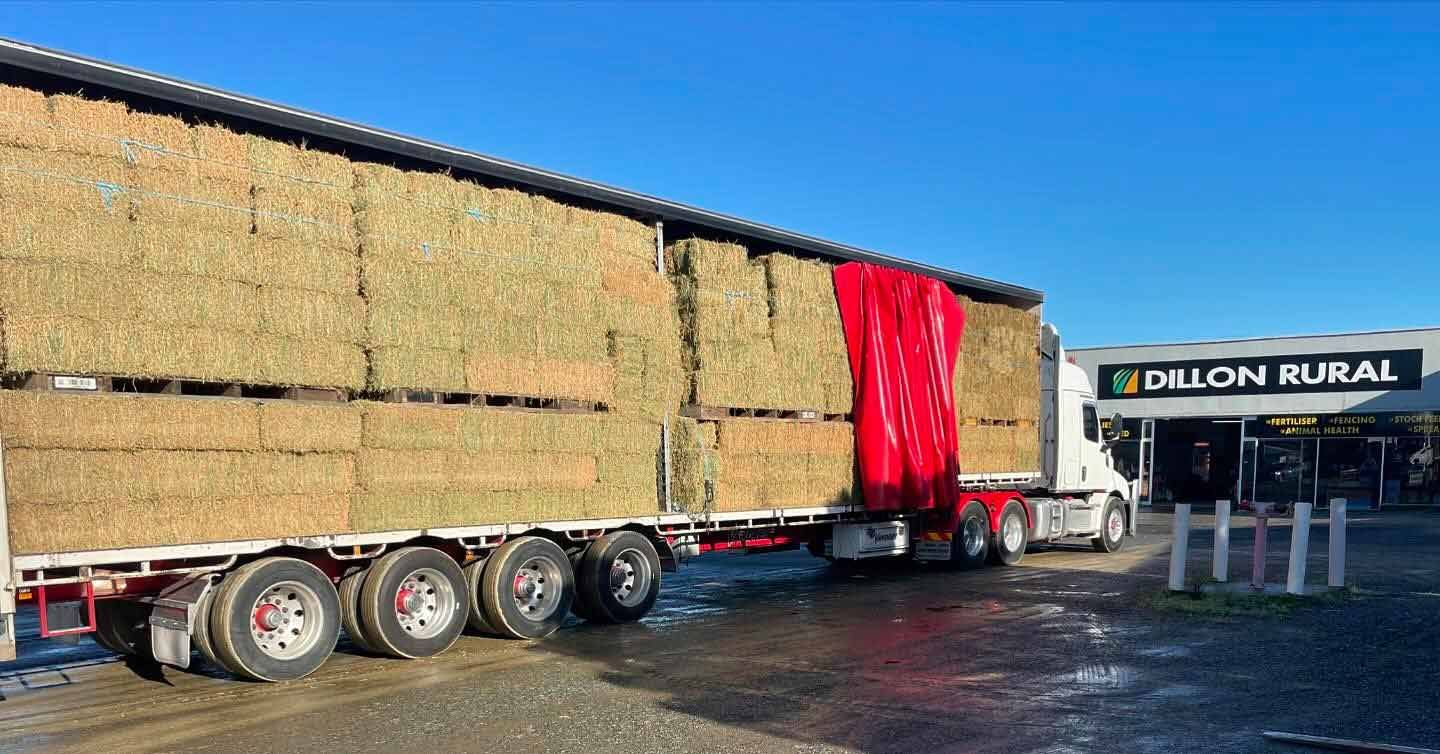 A Large Trailer Filled With Hay Is Parked In Front Of A Building — Dillon Rural In Cundletown, NSW
