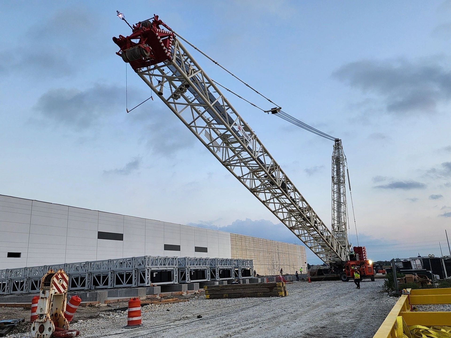 Construction crane lifting at a building site, overcast sky.