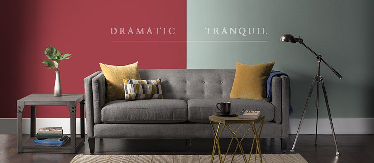 Paint advertisement with modern gray couch set against split color wall, one side medium gray and one side muted red