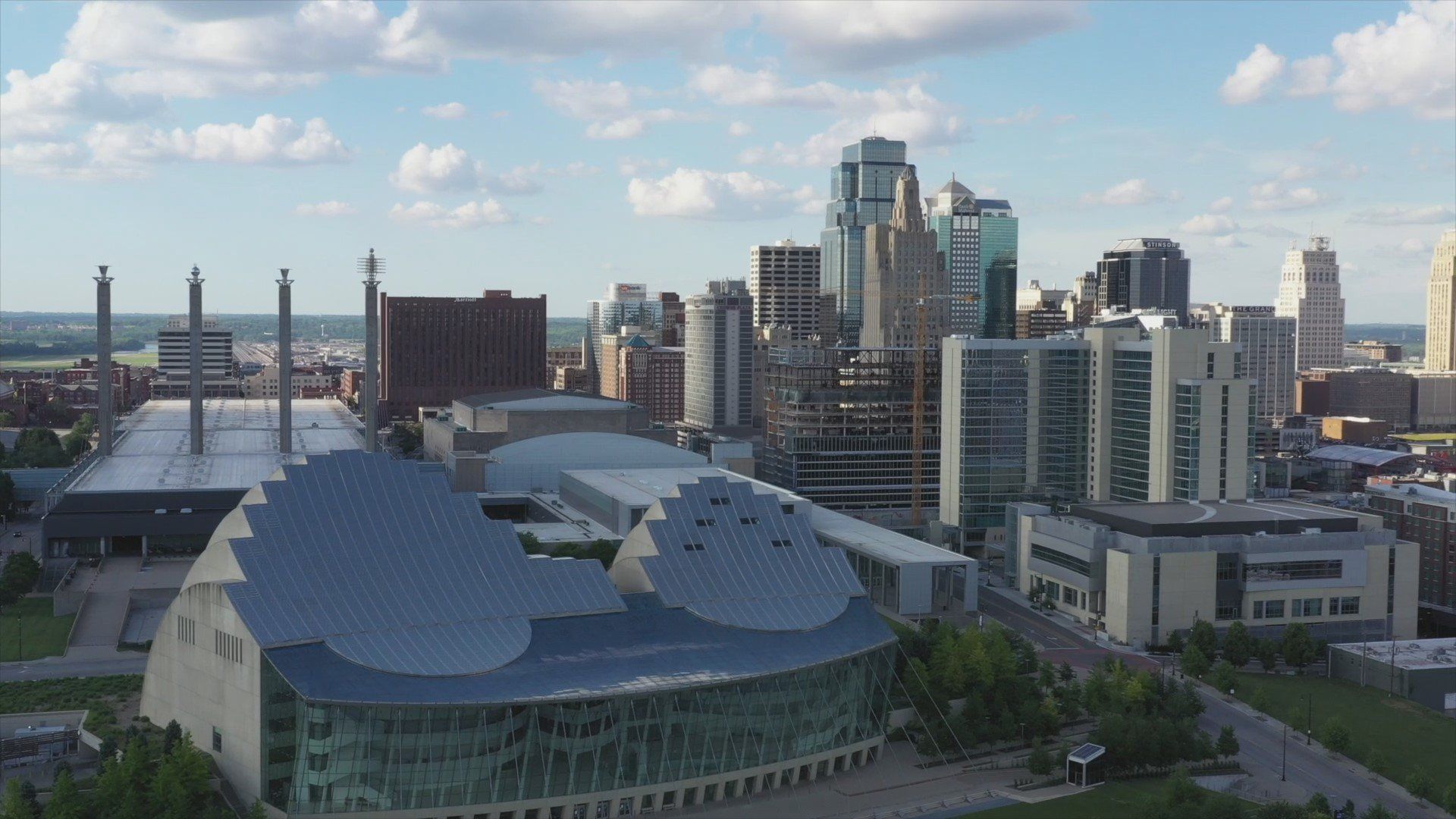 Downtown Kansas City aerial shot showing Kauffman Performing Arts center in the front with the 4 pillars of Bartle Hall behind and the skyscrapers filling in