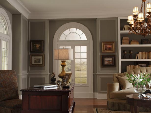 A home office and sitting room in a cozy, traditional style with a medium-gray paint