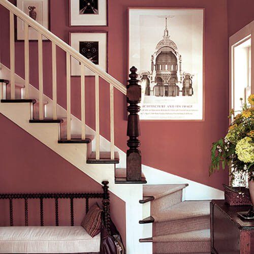 Staircase in home with trendy muted red paint against clean white trim