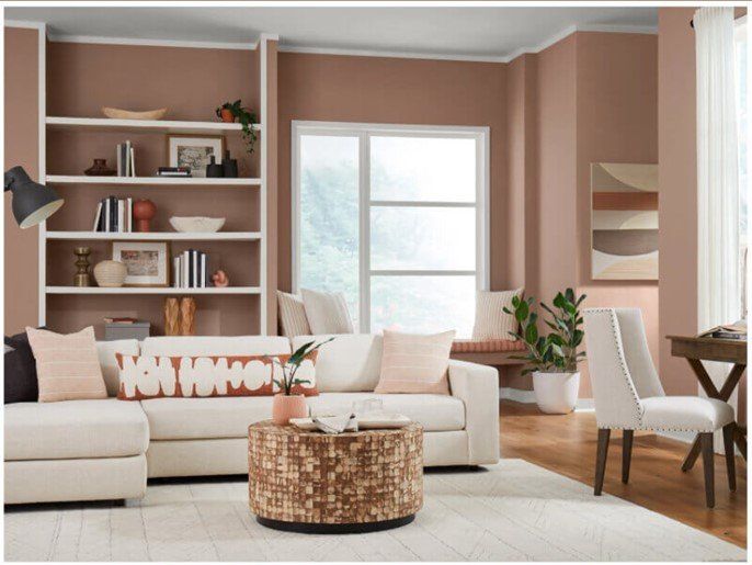 Living room home interior with modern, minimalist style - a color scheme of light dusty-rose walls with off-white trim and furnishings.