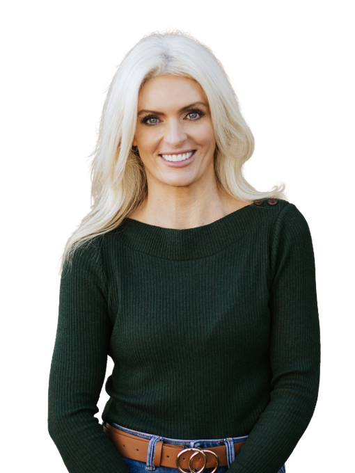 A woman wearing a black jacket and jeans is standing with her arms crossed.