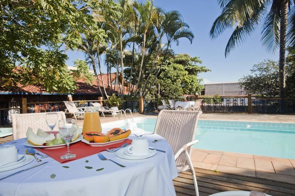 Uma mesa com comida em frente a uma piscina