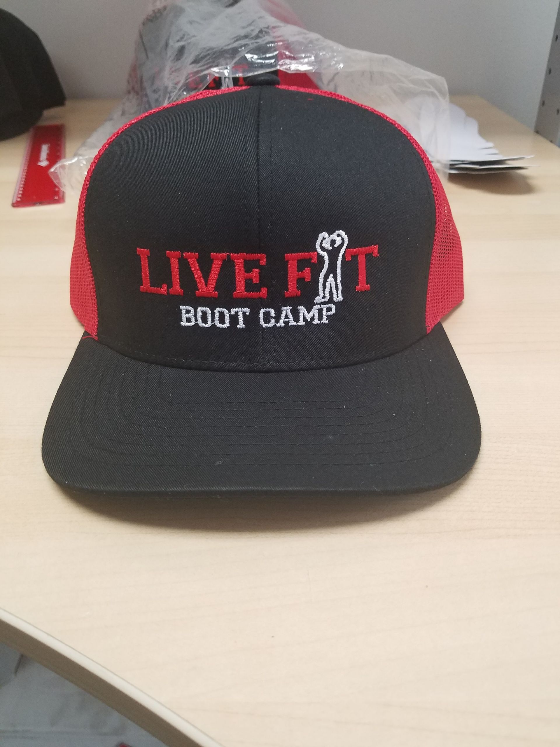 A black and red mesh snapback hat featuring 