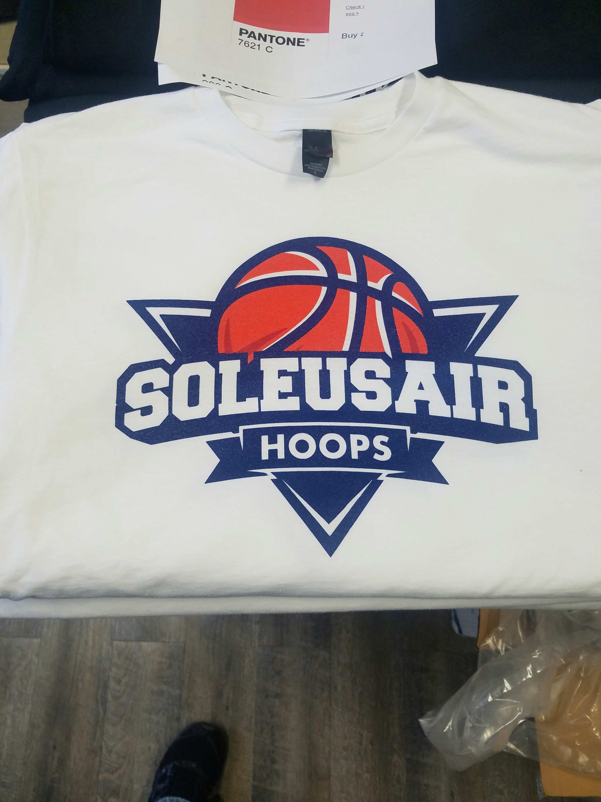 A white t-shirt featuring a basketball graphic with the text 