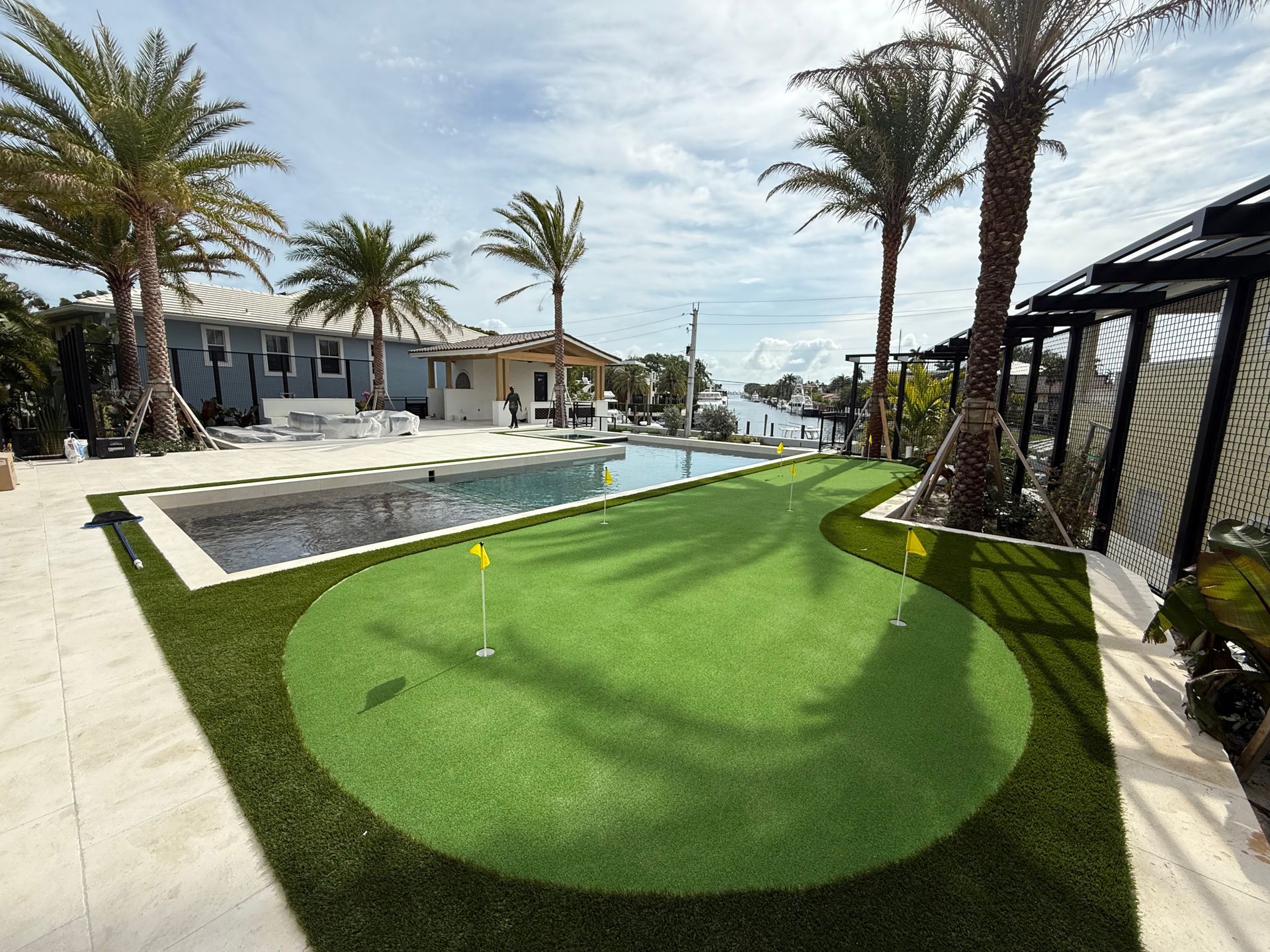 Artificial grass surrounding a custom-built pool with a custom-crafted putting green in South Florid