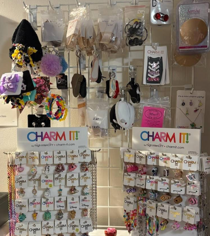 Dancewear shop display with racks of leotards, tutus, and shoes on shelves.