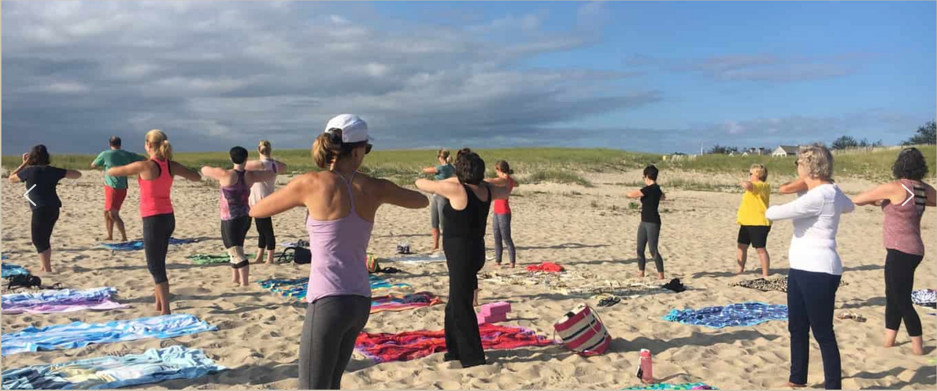 A group of people are doing yoga on the beach