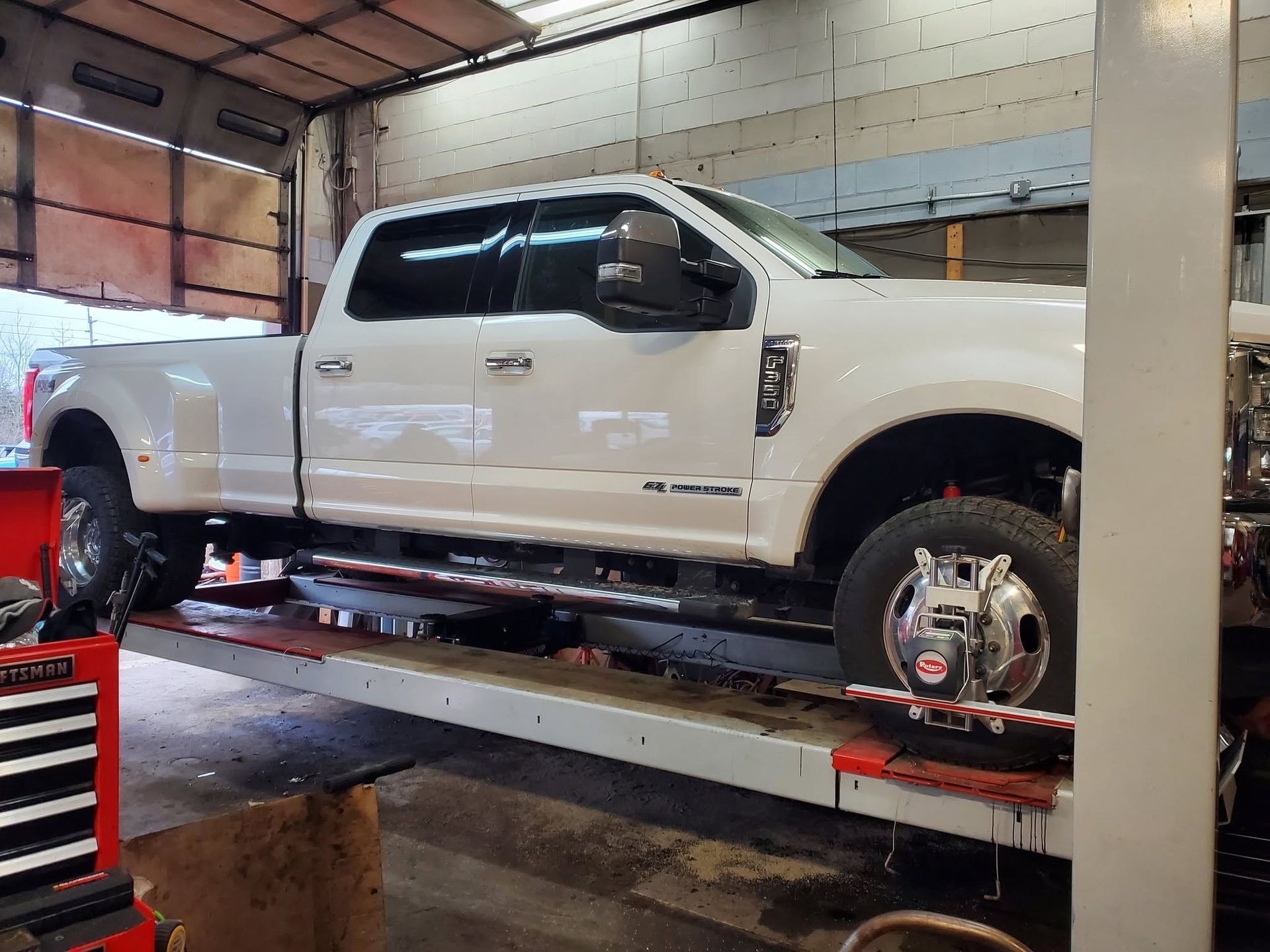 White Pickup Truck On Service Lift | JK Auto And Truck Repair