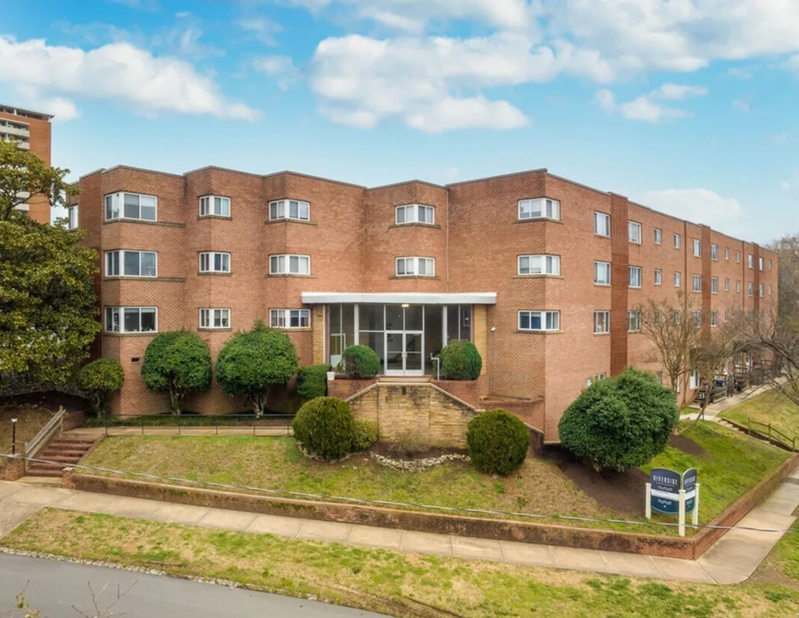 An aerial view of a large brick building with trees in front of it.