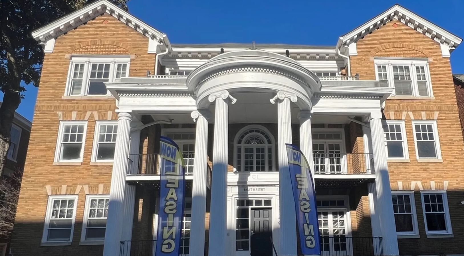 A large brick building with columns and a blue banner.