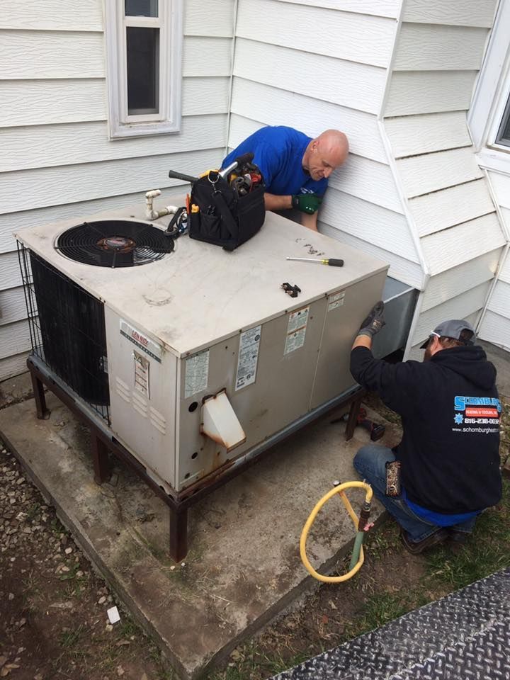 man working on an ac unit outside