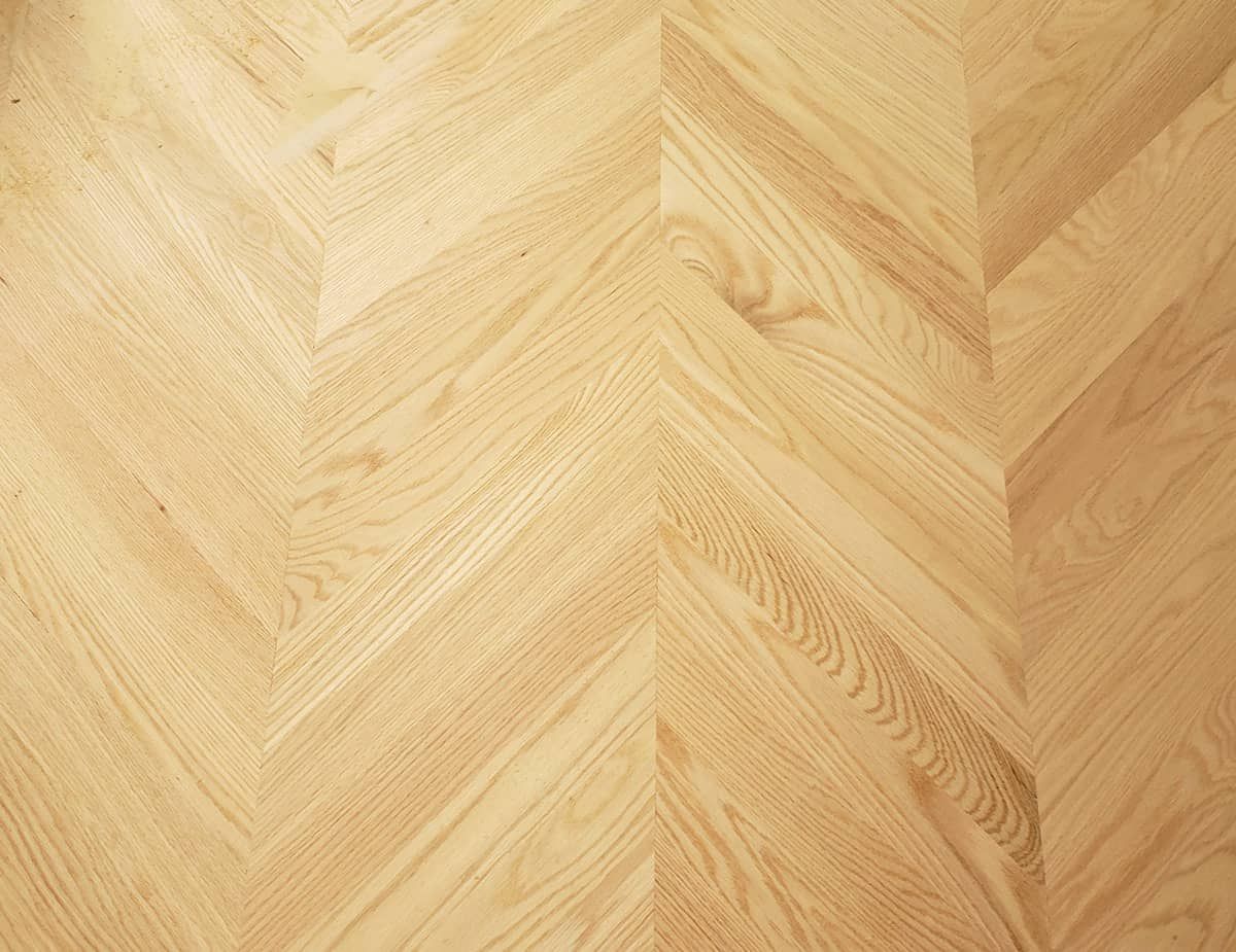 Herringbone pattern wood floor, light tan color.