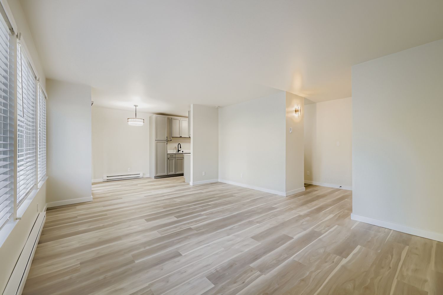 Photo of a large living room with the kitchen in the background